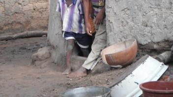 Children look out from the doorway to their home