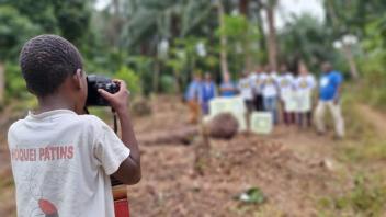 A child takes a photo of the collection team in the distance