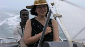 Two people on a boat in the wind.