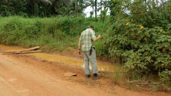 Anton collecting larvae from a puddle on the road