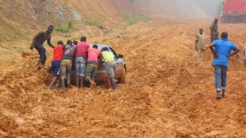 Pushing a car up a muddy hill