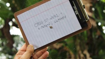 A spider is shown in front of a clipboard with the coordinates of it's collection site shown