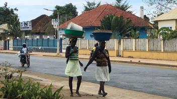 Women walking with buckets on their heads