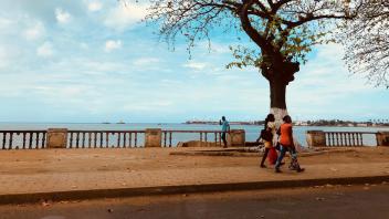 People walking along the street at the edge of the water